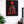 Framed canvas art with a red and black design of a figure on a throne in a room with a plant and desk.